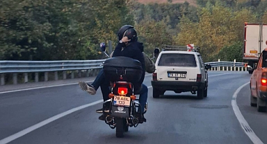 Motosiklette bacak bacak üstüne atarak yolculuk yaptı